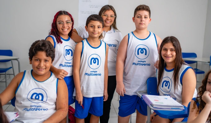 Alunos do Colégio Multiverso Messejana reunidos em sala de aula, com colegas sorrindo